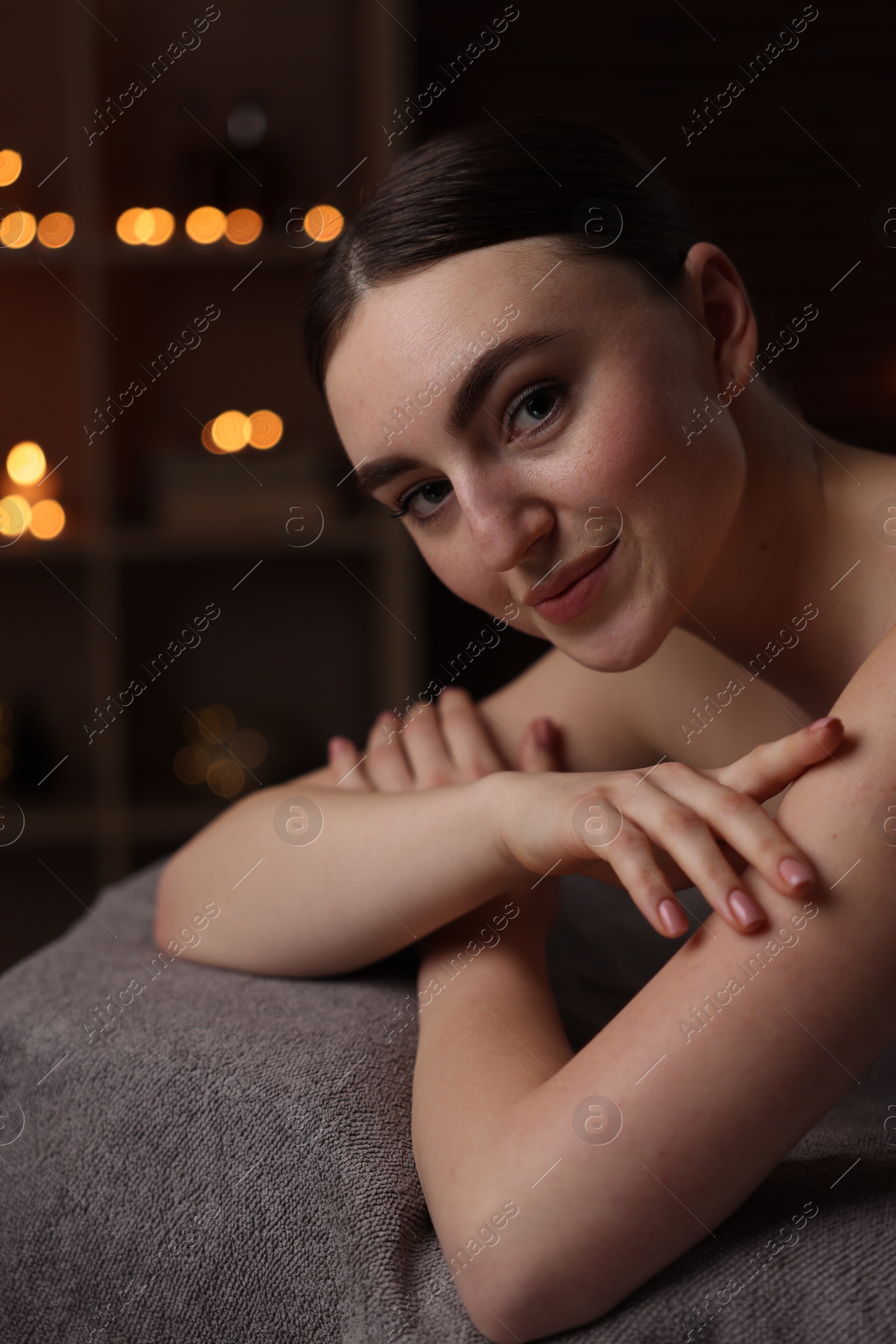 Photo of Spa therapy. Beautiful young woman lying on massage table in salon