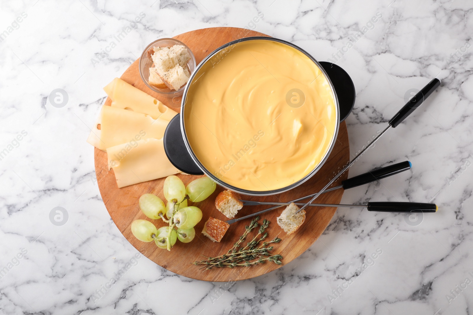 Photo of Flat lay composition with pot of delicious cheese fondue on marble table