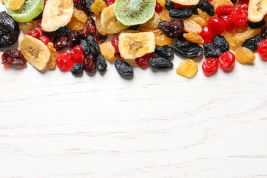Photo of Different dried fruits on wooden background, top view with space for text. Healthy lifestyle