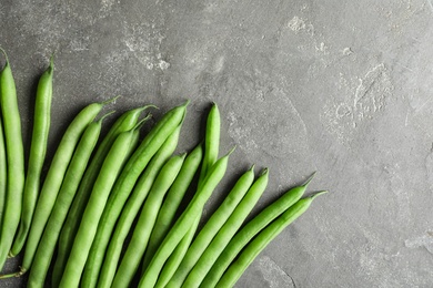 Photo of Fresh green beans on grey table, flat lay. Space for text