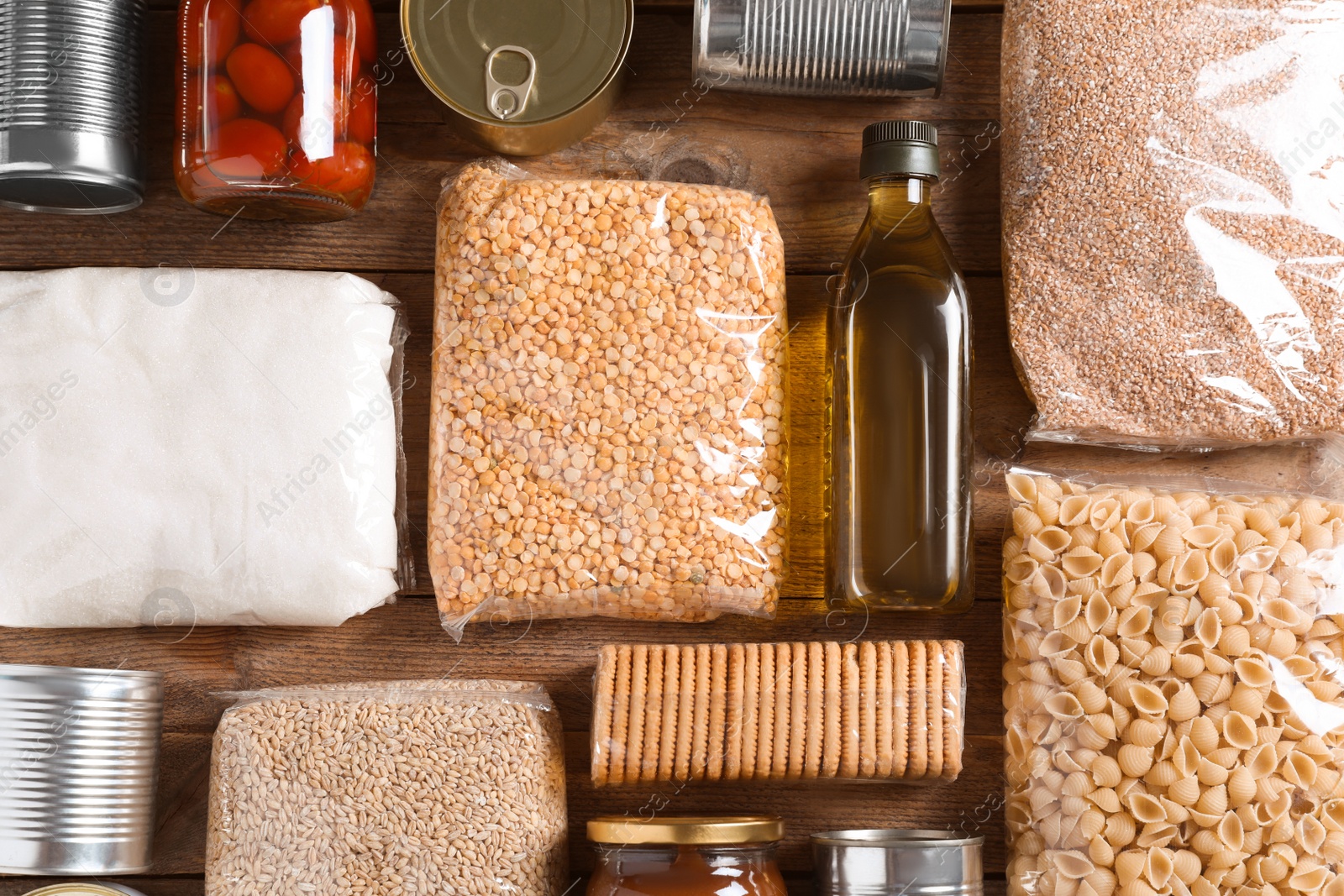 Photo of Different products on wooden table, flat lay. Food donation