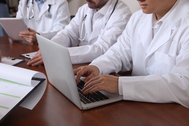 Photo of Team of doctors working with papers during medical conference indoors, closeup