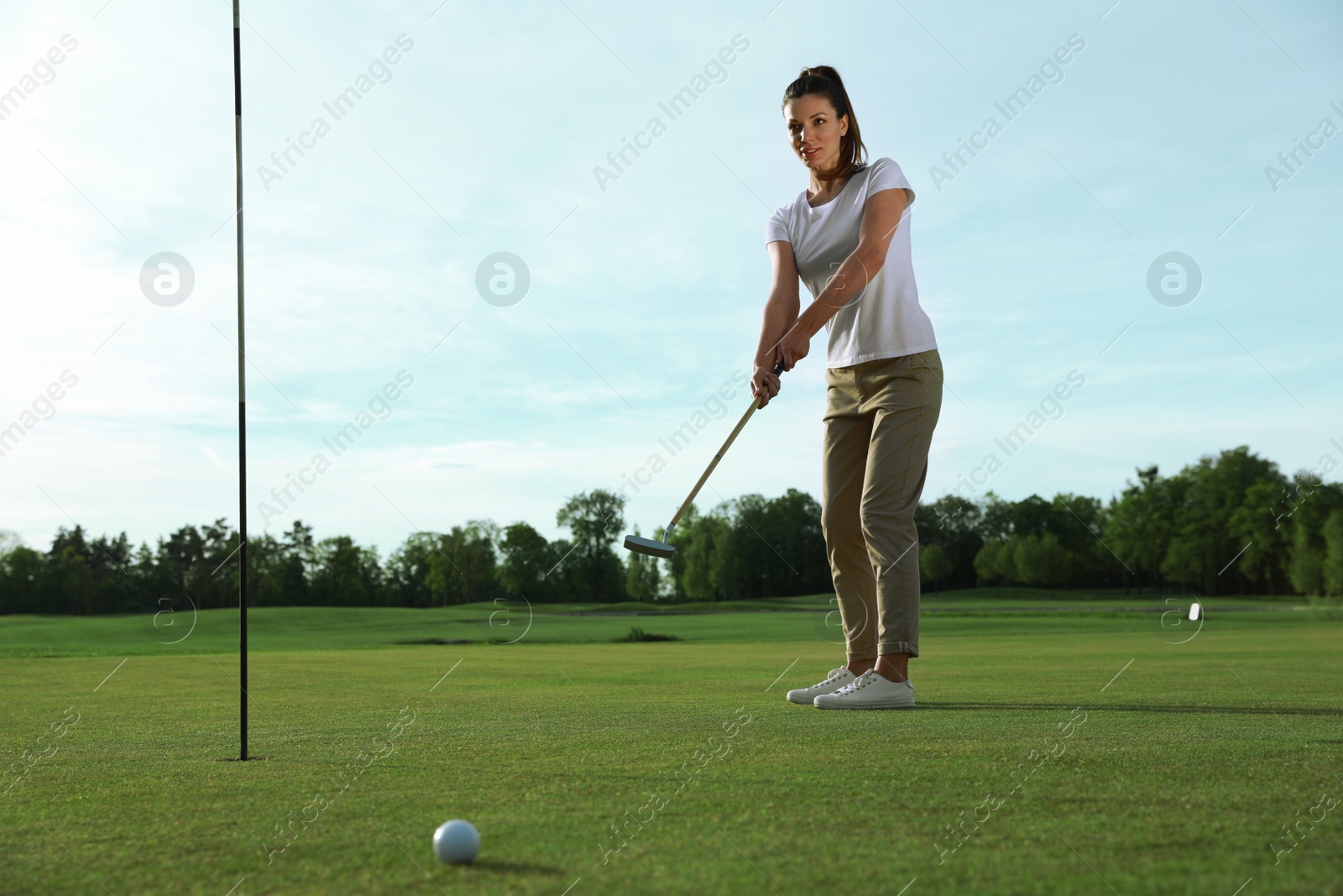 Photo of Beautiful woman playing golf on green course