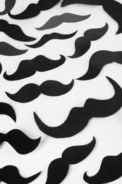 Fake paper mustaches on white background, flat lay