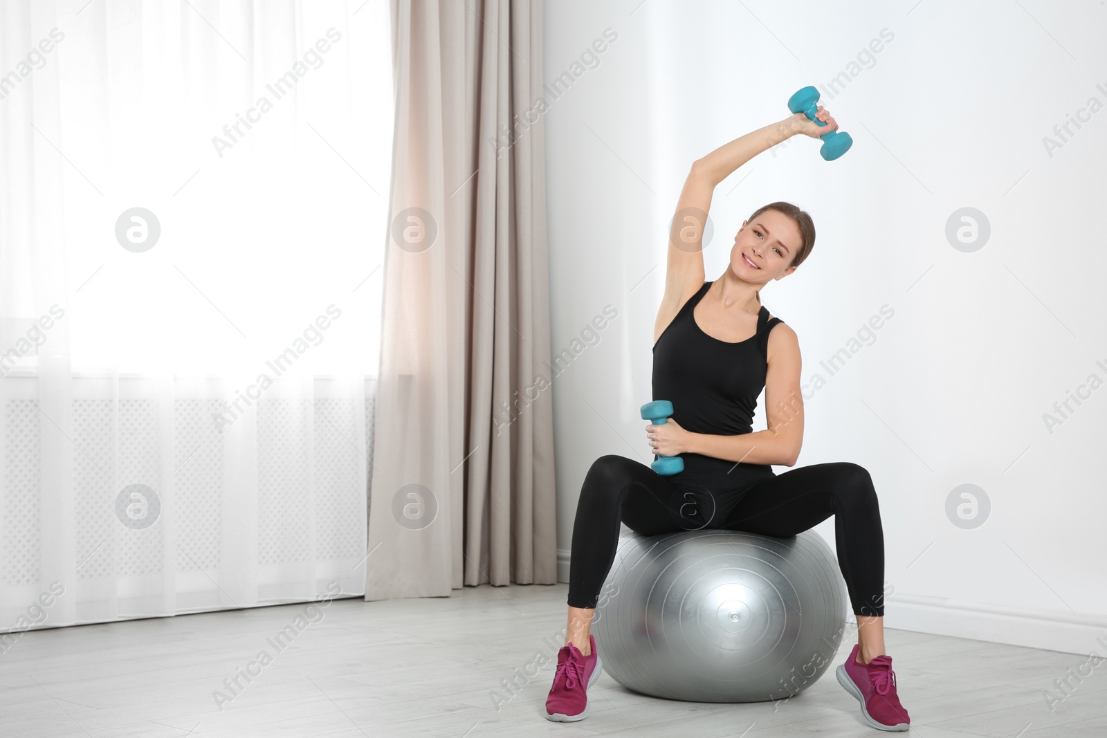 Photo of Young woman doing fitness exercises at home. Space for text