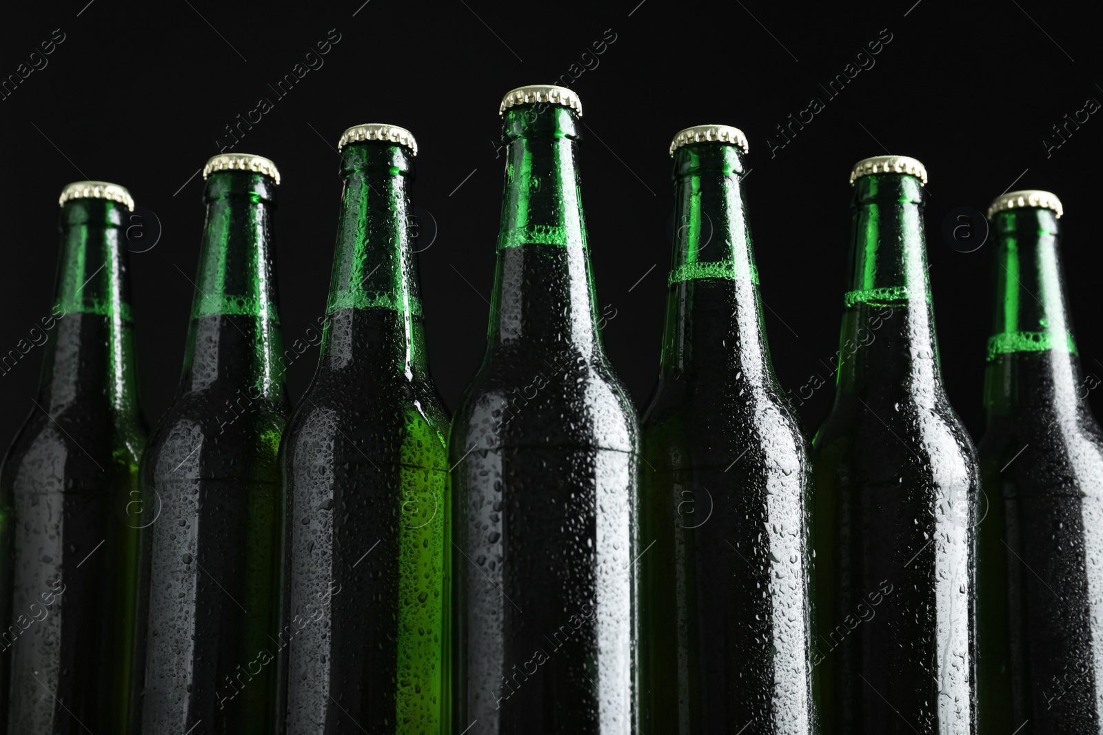 Photo of Bottles of beer on black background, closeup