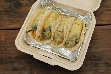 Photo of Jalapeno peppers stuffed with cheese in box on wooden table, above view