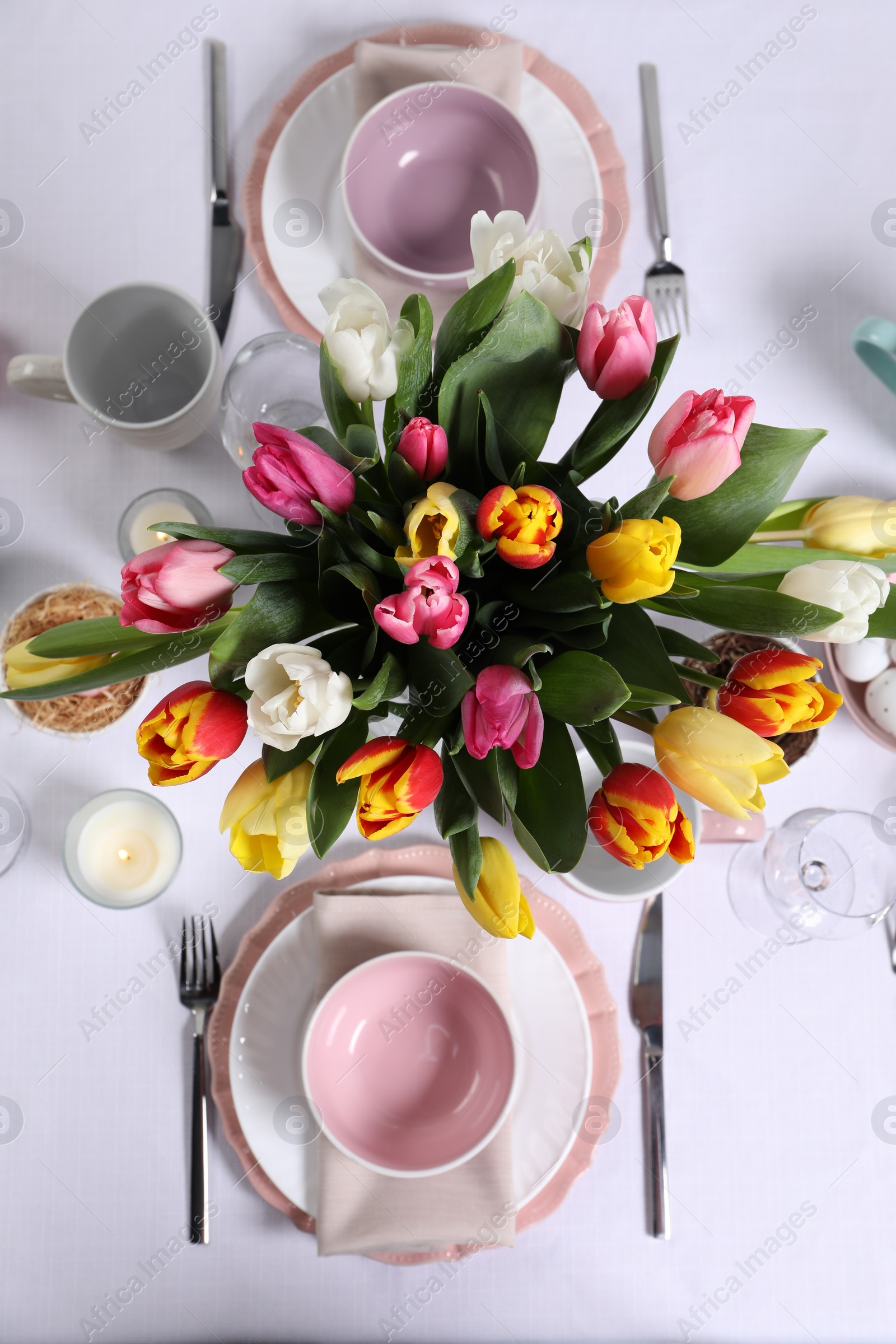 Photo of Festive table setting with beautiful flowers, flat lay. Easter celebration