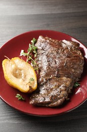 Photo of Delicious roasted beef meat, caramelized pear and thyme on grey wooden table, closeup