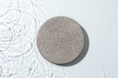 Photo of Presentation for product. Stone podium in water on white background, top view