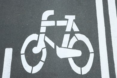 Photo of Bicycle lane with white sign painted on asphalt, above view