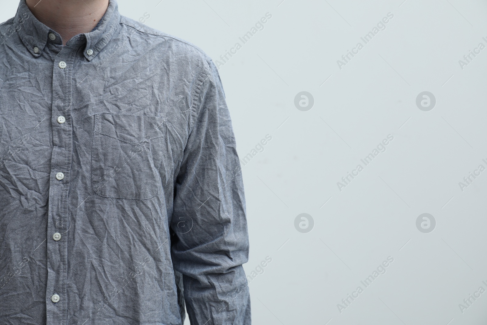 Photo of Man wearing creased shirt on light background, closeup. Space for text