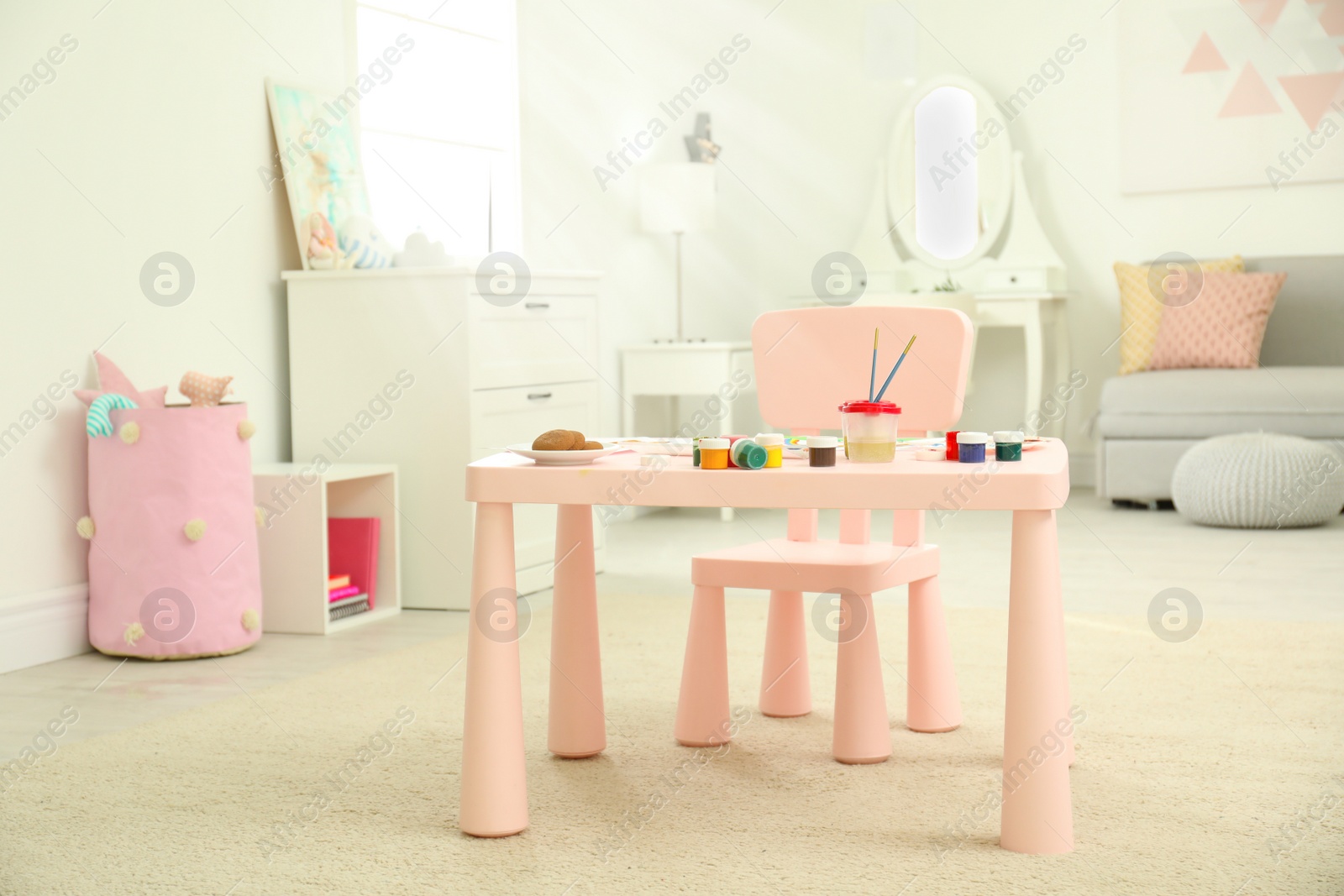 Photo of Pink children's table for painting in room