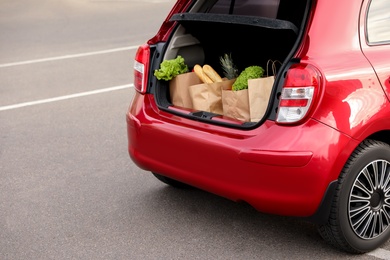 Bags full of groceries in car trunk outdoors