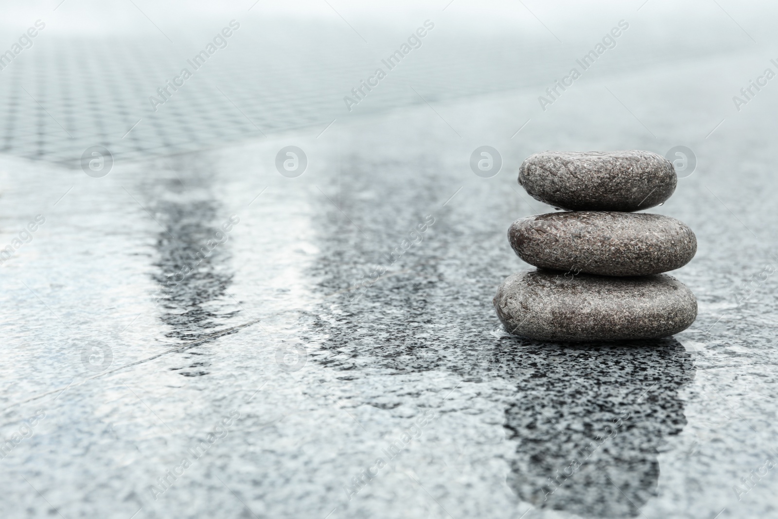 Photo of Stack of spa stones on wet city street, space for text