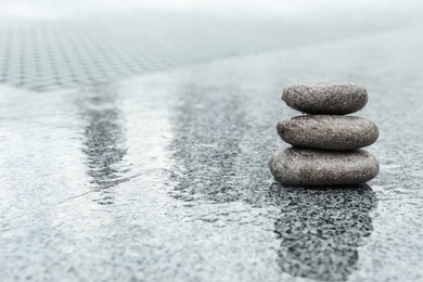 Photo of Stack of spa stones on wet city street, space for text