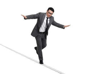 Risks and challenges of owning business. Man balancing on rope against white background