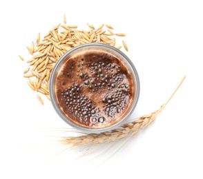 Cup of barley coffee, grains and spike on white background, top view