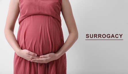 Surrogacy. Pregnant woman touching her belly on light background, closeup. Banner design