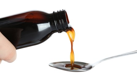 Photo of Pouring cough syrup into spoon on white background