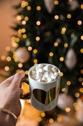 Photo of Woman with cup of cocoa indoors, closeup. Christmas mood