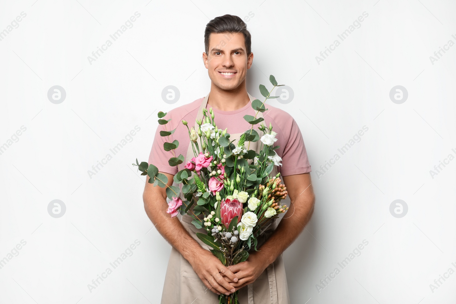 Photo of Florist with beautiful bouquet on light background