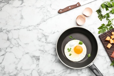 Photo of Pan with fried sunny side up egg served on table, flat lay with space for text