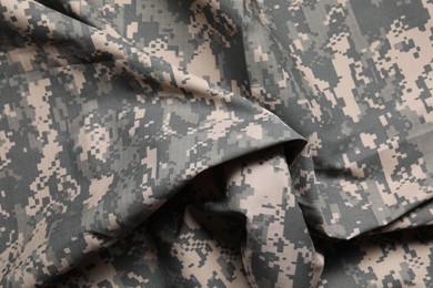 Photo of Texture of crumpled camouflage fabric as background, top view