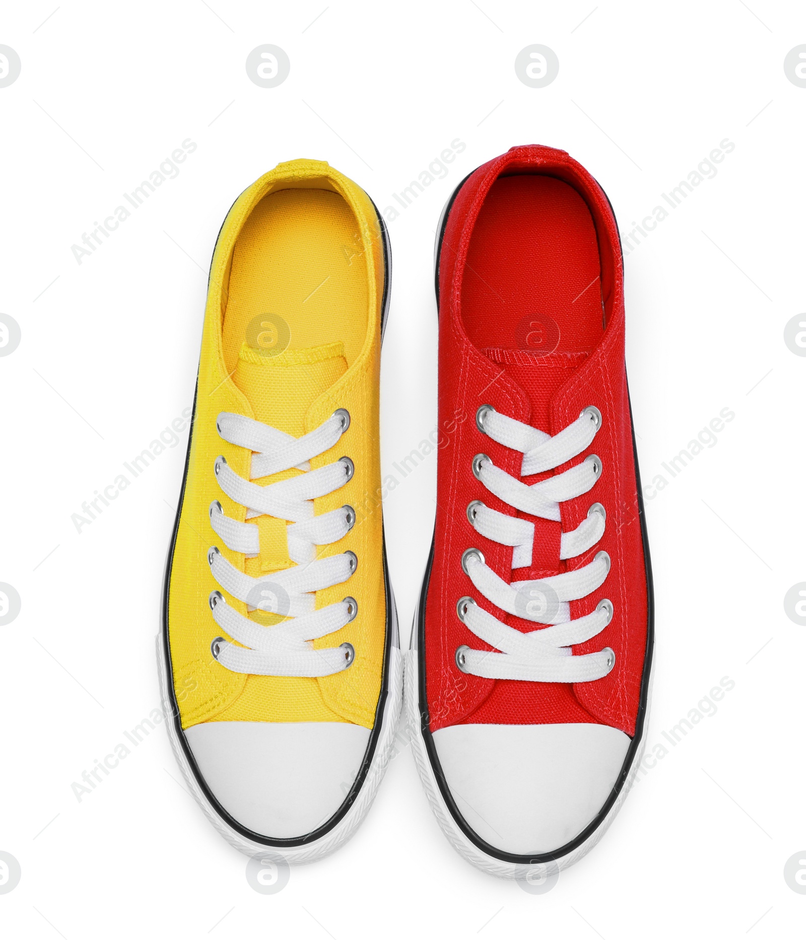 Photo of Yellow and red classic old school sneakers isolated on white, top view