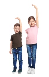 Photo of Little children measuring their height on white background