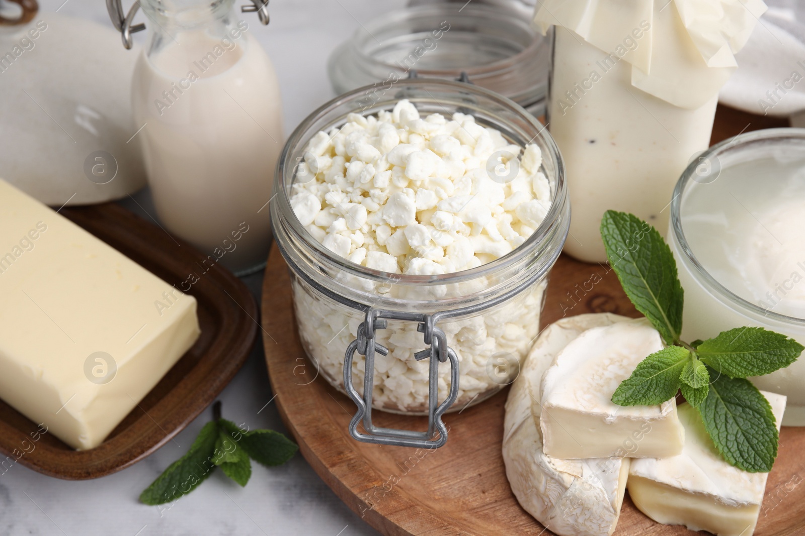 Photo of Different dairy products and mint on white marble table