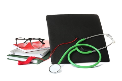 Stethoscope notebooks and graduation hat on white background. Medical students stuff