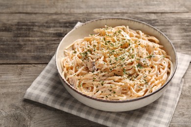 Photo of Delicious pasta with mushroom sauce on wooden table
