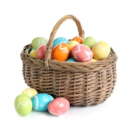 Wicker basket with painted Easter eggs on white background