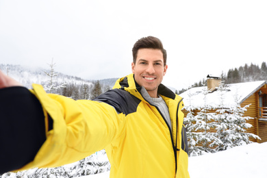 Happy man taking selfie at resort. Winter vacation