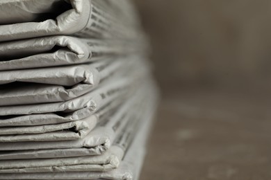 Stack of newspapers on table, closeup with space for text. Journalist's work