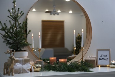 Photo of Mirror over shelf with Christmas decor in room. Interior design