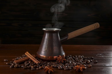 Photo of Turkish coffee in cezve, beans and spices on wooden table