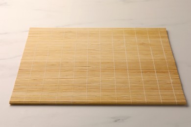 Photo of New bamboo mat on white marble table