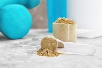 Measuring spoons with hemp protein powder on table