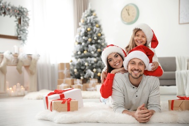 Photo of Portrait of happy family with Christmas gifts on floor at home