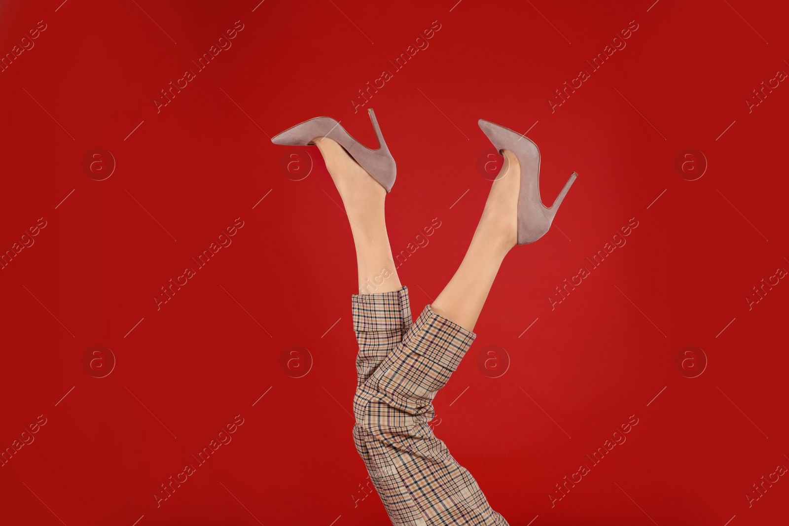 Photo of Woman in elegant shoes on red background