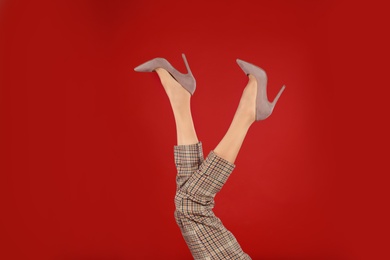 Woman in elegant shoes on red background