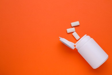 Photo of Jar with chewing gums on orange background, flat lay. Space for text