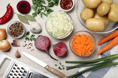 Photo of Fresh ingredients for borscht on white wooden table, flat lay