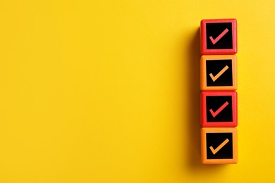 Image of Cubes with check marks on orange background, top view. Space for text