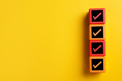 Cubes with check marks on orange background, top view. Space for text