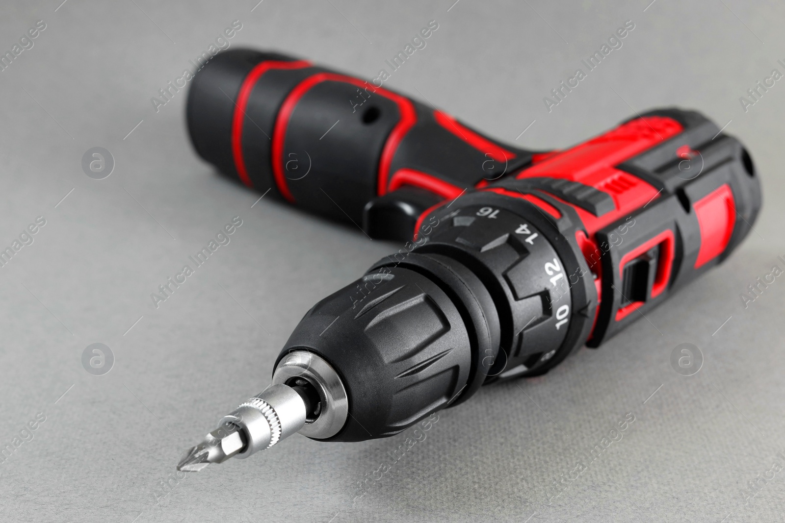 Photo of Modern cordless electric screwdriver on grey background, closeup. Space for text