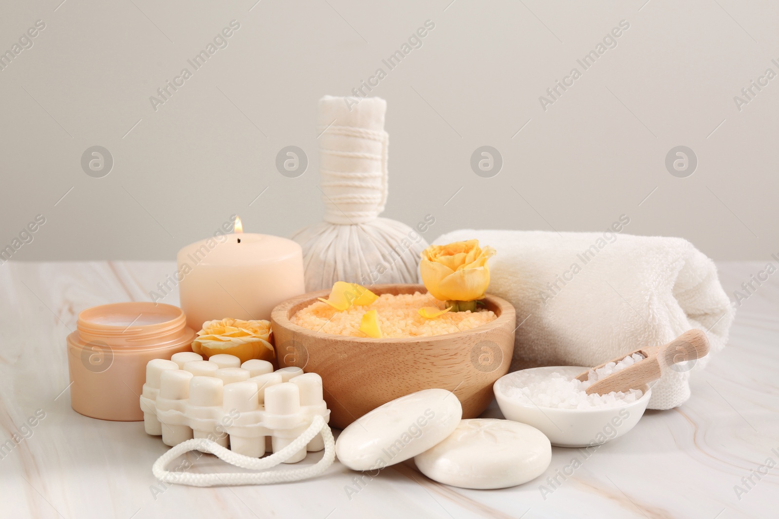 Photo of Sea salt, different spa products and beautiful rose on white marble table