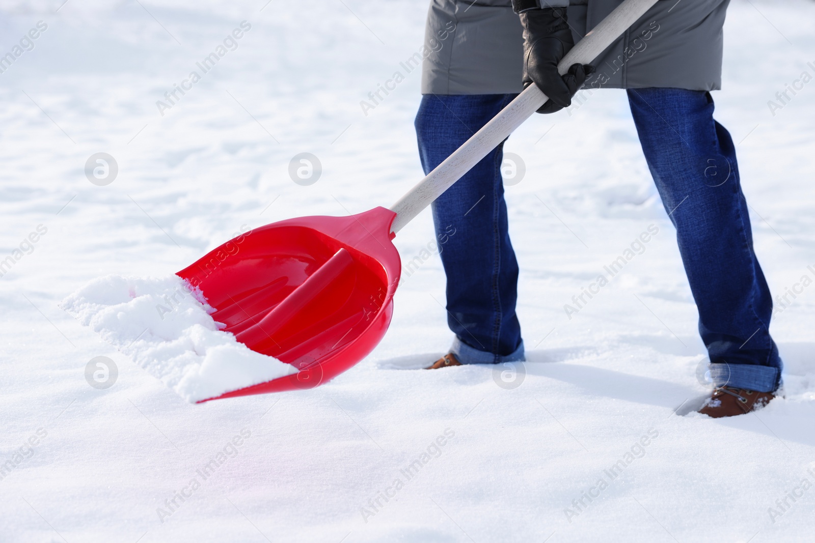 Photo of Man removing snow with shovel outdoors, closeup